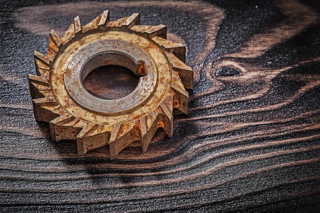 Rusty rotary cutter on vintage wooden background construction concept