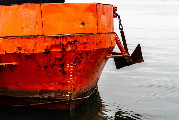 Rusty ship in sea against orange sky