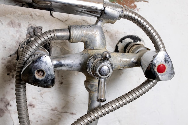 Rusty water faucet on a white wall