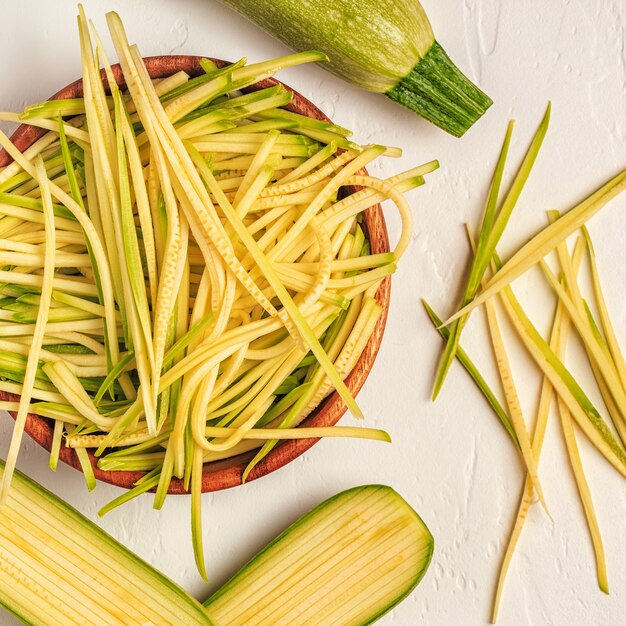 Ruwe courgette deegwaren op witte achtergrond