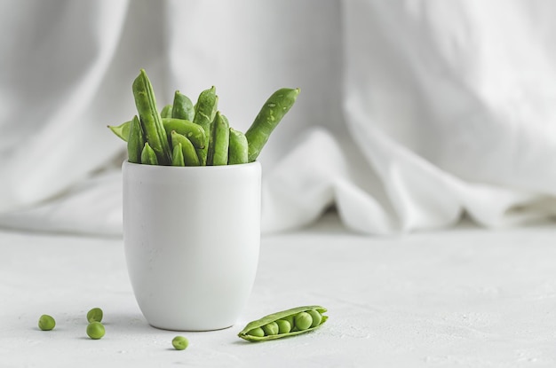 Ruwe groene erwtenpeulen op lichte achtergrond