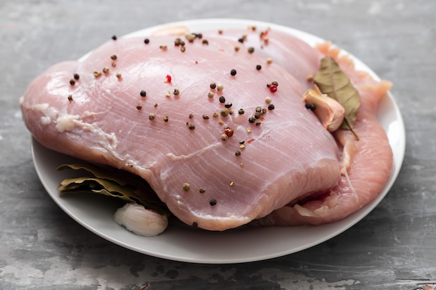 Ruwe kalkoen met zwarte peper en knoflook op schotel