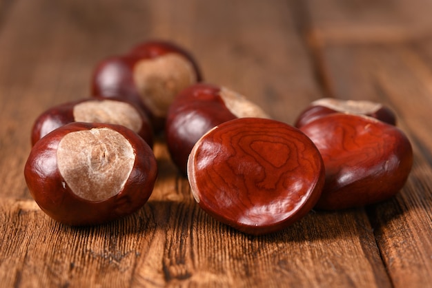 Ruwe kastanjes op een houten tafel.