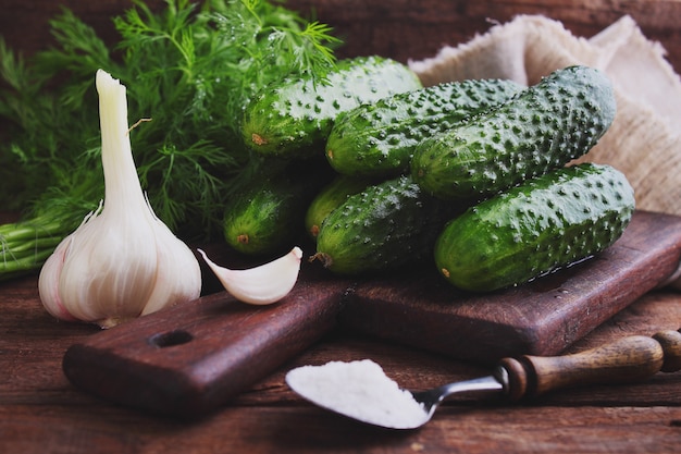 Ruwe komkommers voor het beitsen op een houten achtergrond