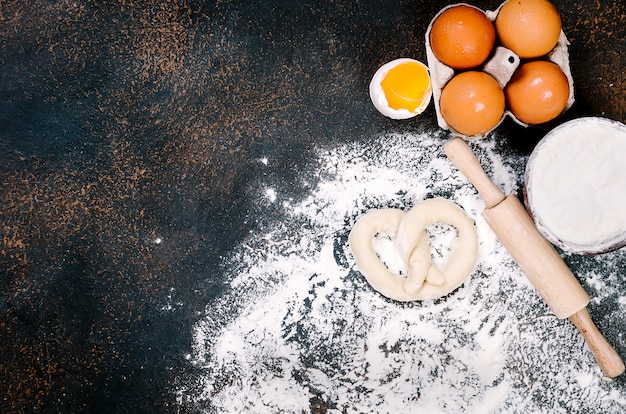 Foto ruwe krakeling op bloem klaar om te worden gebakken en ingrediënten