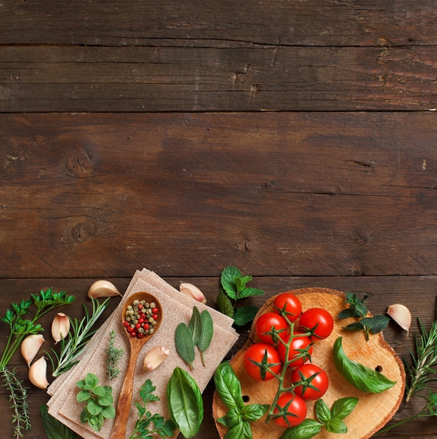 Ruwe lasagne pasta, groenten en kruiden op een houten tafel