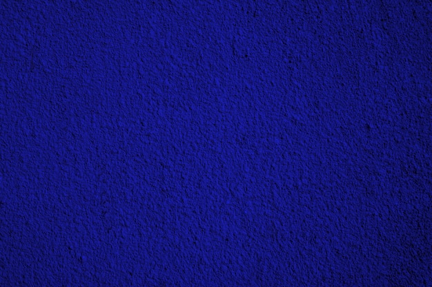 Ruwe marineblauw gips of stucwerk muur. Afgezwakt. Abstracte grungeachtergrond met exemplaarruimte.