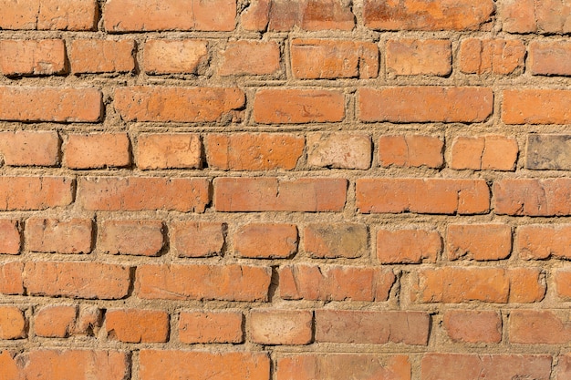 Ruwe ongelijke textuur oude rode bakstenen muur close-up