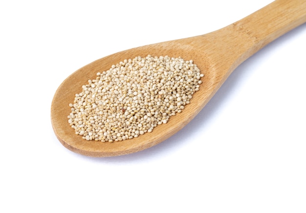 Ruwe quinoa korrels in een lepel geïsoleerd op witte achtergrond.