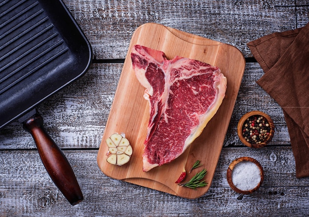 Ruwe T-bone steak en ijzeren grillpan