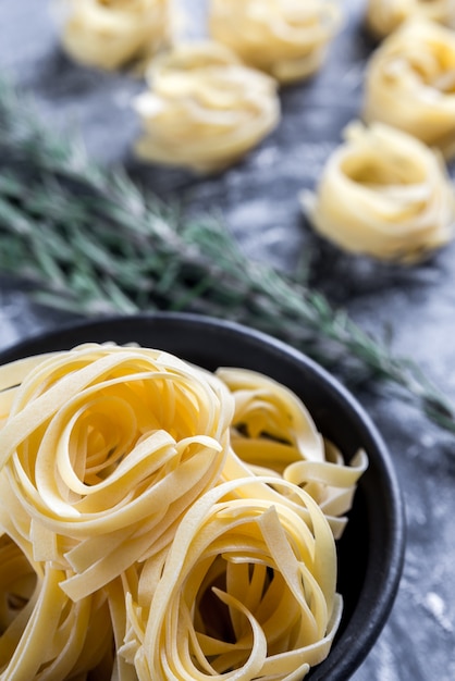 Ruwe tagliatelle nido op met bloem bestoven zwart hout