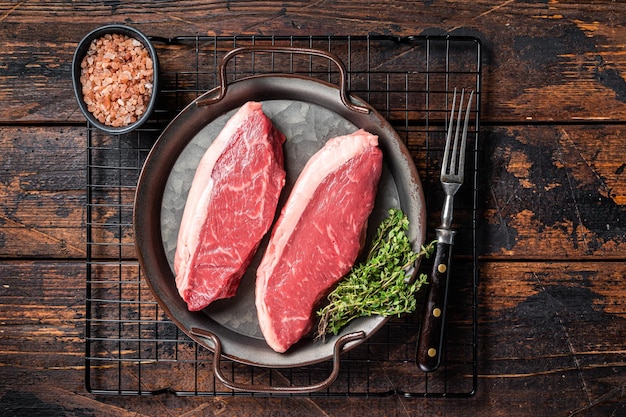 Ruwe top entrecote cap rumsteak vlees steak op keukenblad met kruiden houten achtergrond bovenaanzicht