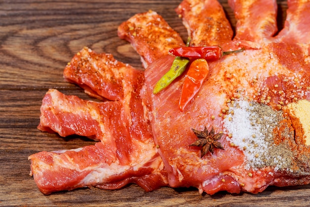 Ruwe varkensribkoets snijplank met chili peper knoflook en olie
