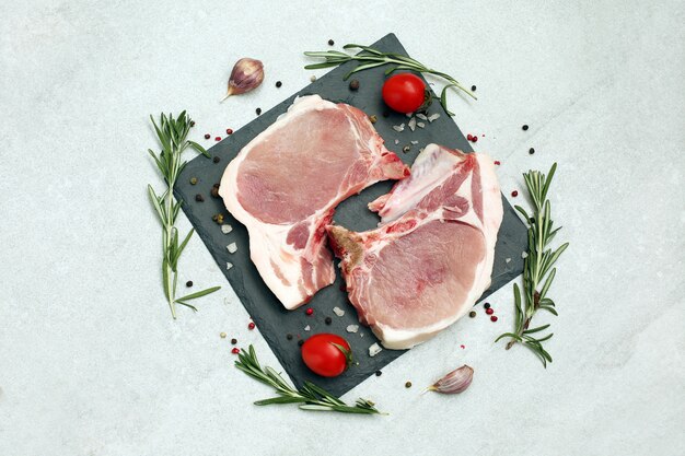 Ruwe varkensvleeslapje vlees op been op lichte oppervlakte
