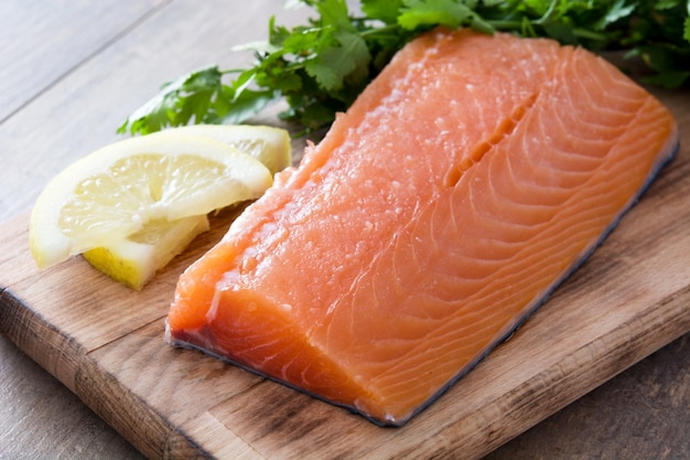 Ruwe zalmfilet op snijplank en houten tafel