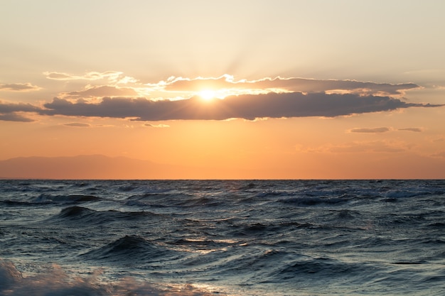 Ruwe zee en zonsondergang erover