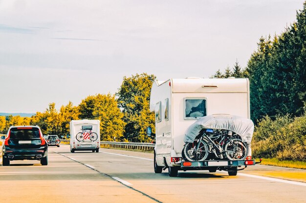 RV Camper Car and bicycles on Road. Caravan and motorhome in trip in Switzerland.