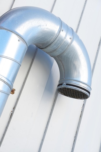 RVS ventilatiekanaal en pijp aan de zijkant van een industrie- en fabrieksmuur Architectonisch ontwerp voor ventilatie en verbrandingsgasregeling Constructieconstructie voor luchtverdeling