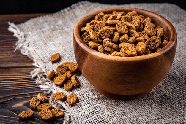 Rye bread crackers on dark wooden background.