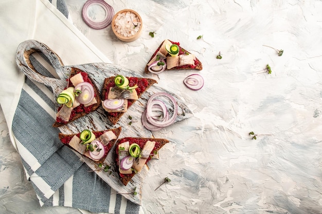 Rye Bread Sandwich Smorrebrod with Herring beetroot salad green cucumber onion and microgreen Toast with herring fillet Scandinavian cuisine