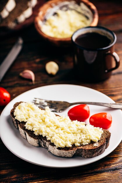 Ржаный тост с сыром и чесноком на белой тарелке