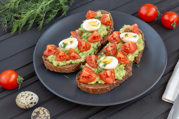 Rye bread with avocado and boiled eggs and cherry tomatoes