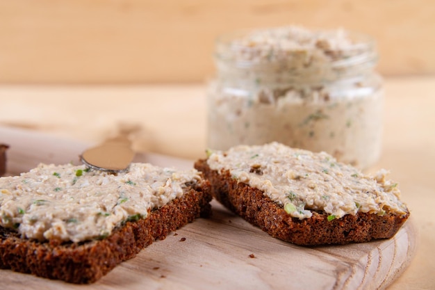 Rye bread with spread that harmonizes perfectly with rustic charm of wooden background