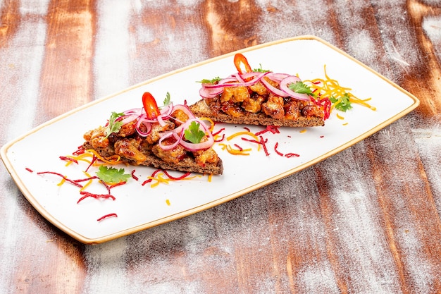 Rye croutons with veal brains and onions On a wooden background