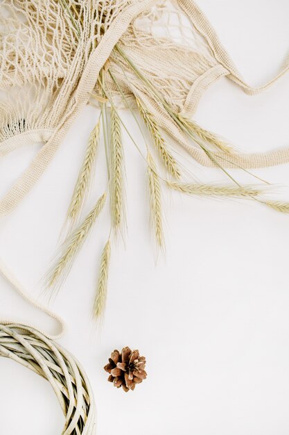 Rye ears in string bag, wreath frame and cone