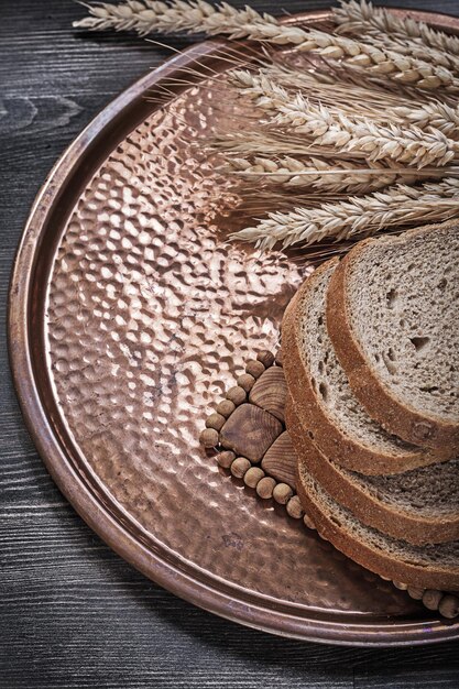 Rye wheat ears sliced loaf of bread vintage brass tray food and drink concept