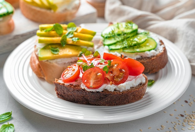 Rye and wheat toast with feta cherry tomatoes avocado and cucumber closeup