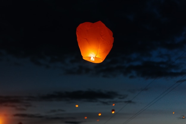 'S Avonds, bij zonsondergang, lanceren mensen met hun familieleden en vrienden traditionele lantaarns. Traditie en reizen.