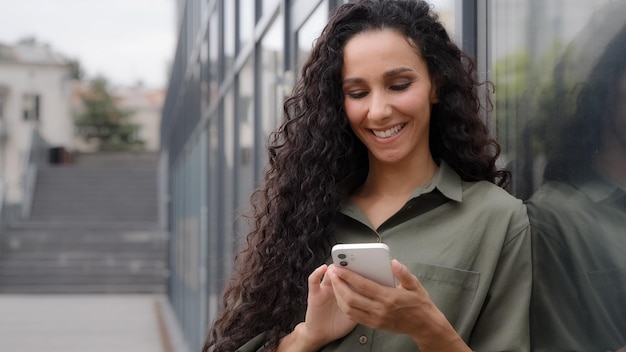 S lady with curly hair girl standing city near glass wall of company office wall chatting with