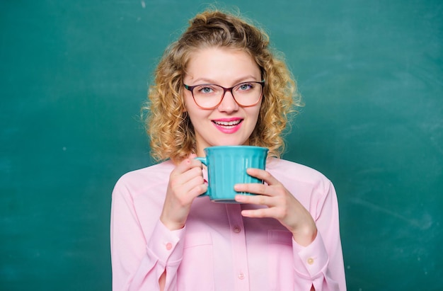 'S ochtends koffie goedemorgen meisje verfrissend met thee drankje idee en inspiratie energie en kracht energiereserves bijvullen vrouw met koffiekopje op schoolbord leraar koffiepauze nodig