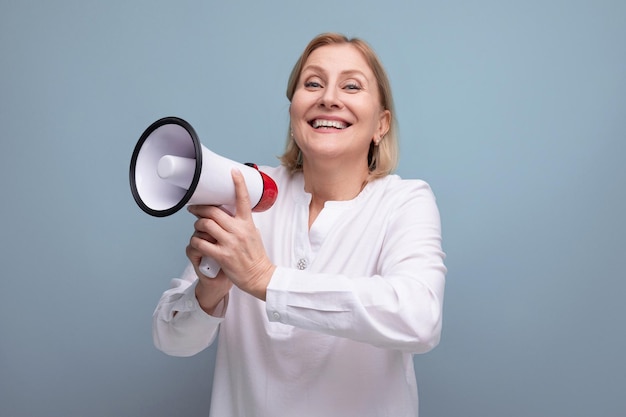 S vrouw met blond kapsel met luidspreker kondigt interessant nieuws aan