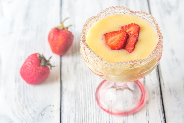 Sabayon with strawberry slices on the wooden background