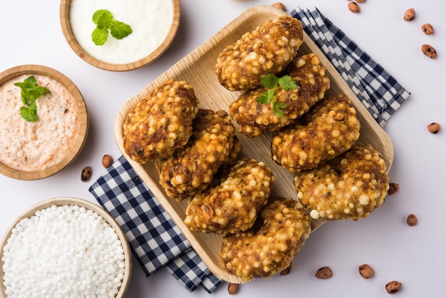 Sabudana vada or Sago fried cake served with peanut chutney over moody background, popular fasting recipe from India.