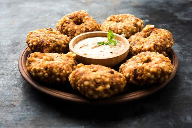 Sabudana vada or sago fried cake served with peanut chutney over moody background, popular fasting recipe from india