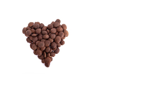 Sacha Inchi roasted seed nuts selective focus on front seeds on white background heart shape