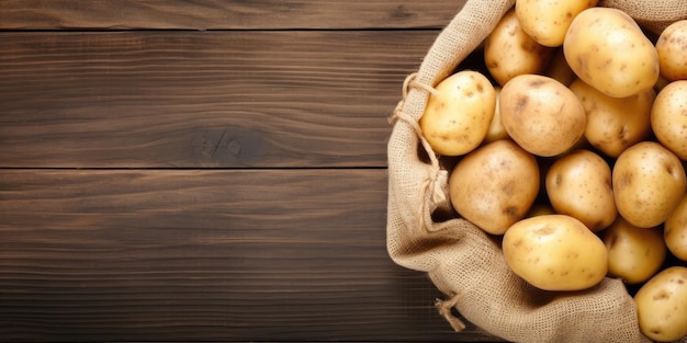 Sack of fresh raw potatoes on wooden background top view