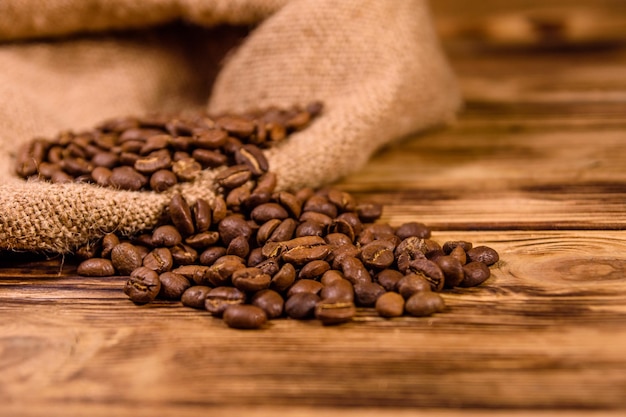 Sackcloth and scattered coffee beans on rustic wooden table