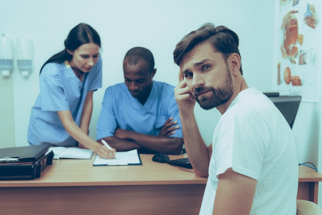 Sad Adult Caucasian Man on Reception at Doctor