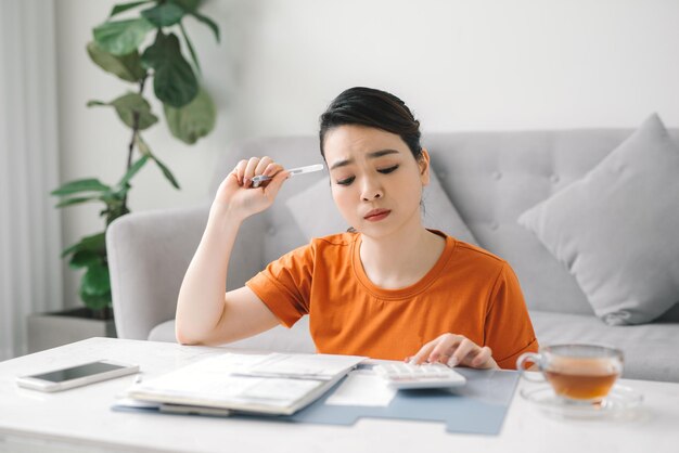 Sad asian woman in financial trouble in living room