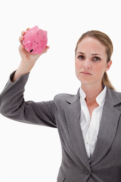 Sad bank employee with empty piggy bank