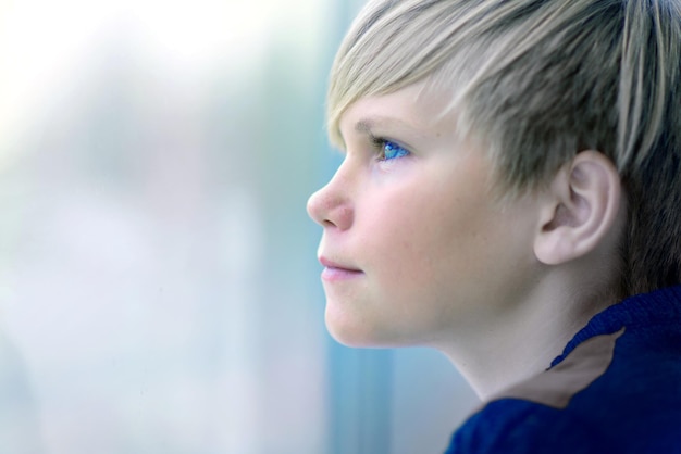 Sad boy looking out of window