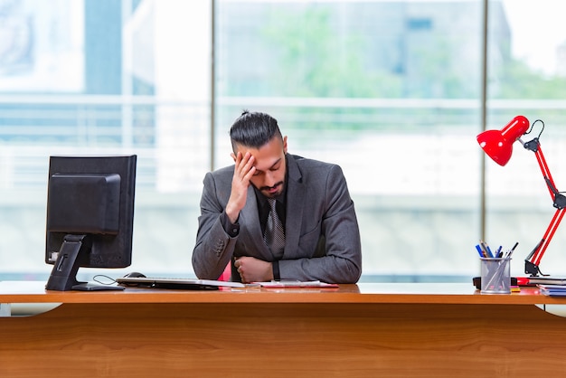 Uomo d'affari triste che si siede nell'ufficio