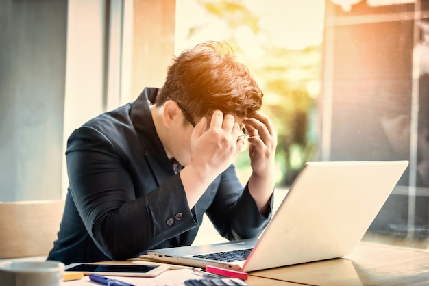 Seduta sollecitata e preoccupata dell'uomo d'affari triste nell'ufficio. concetto di stress e preoccupazione. tono vintage