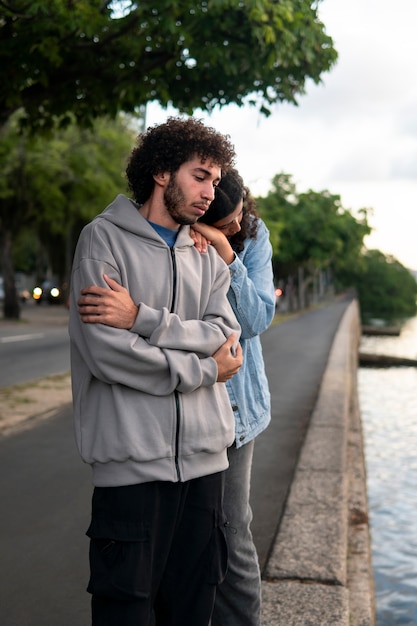 Foto coppia triste e contemplativa accanto al lago