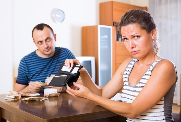 Photo sad couple counting budget 
