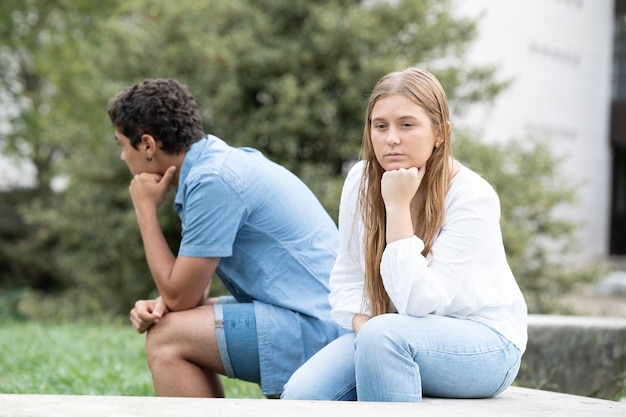 Sad couple sitting back to back